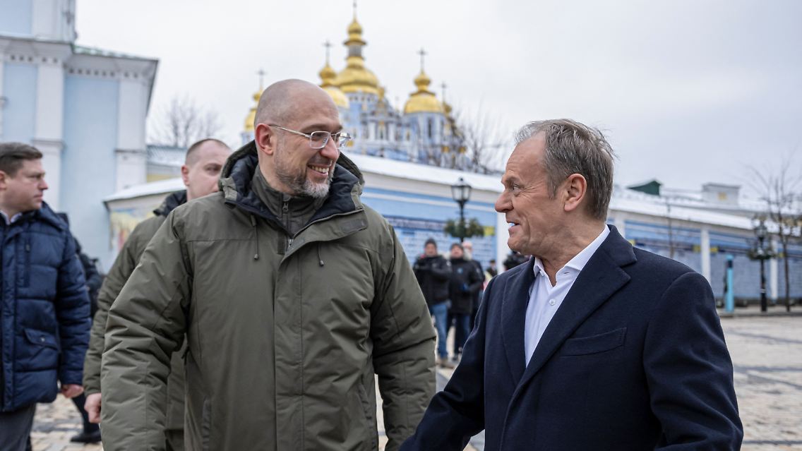 Der polnische Ministerpräsident Tusk und sein ukrainischer Amtskollege Shmyhal gehen über den Mykhailivksa-Platz in Kiew.