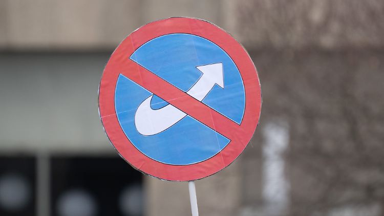 Bundesweit demonstrieren Menschen gegen Rechtsextremismus. Teilnehmer einer Demo in Stuttgart halten ein Schild mit einem durchgestrichenen Logo der AfD in die Höhe. 