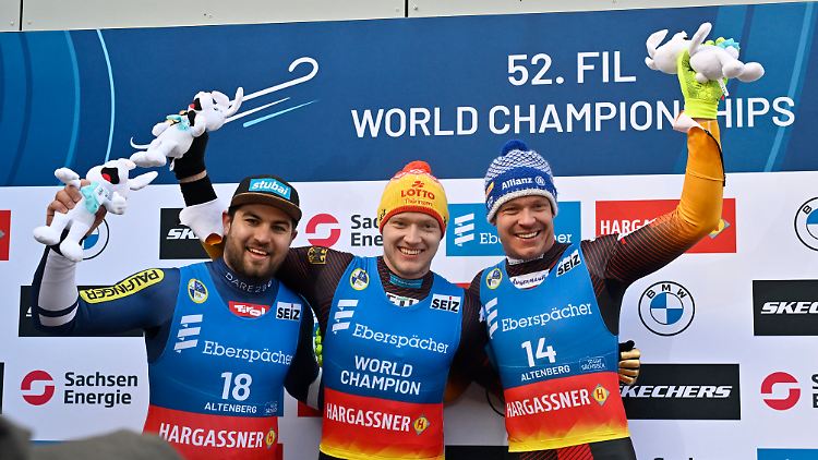 Max Langenhan (Mitte) und Felix Loch (r.) feiern Gold und Bronze bei der Heim-WM in Altenberg.