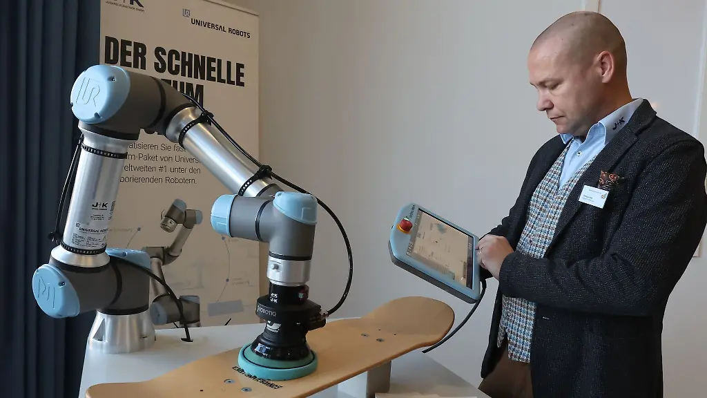 Christian-Held-von-der-Firma-Jugard-Kuenstner-arbeitet-an-einer-Roboter-Schleifmaschine