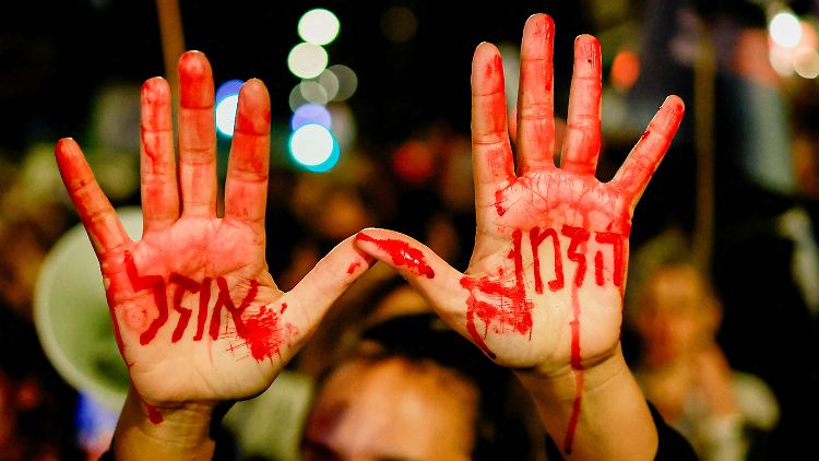 Vor der Residenz des israelischen Ministerpräsidenten in Jerusalem hat ein Demonstrant "Die Zeit läuft ab" auf seine Hände geschrieben.