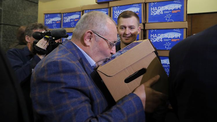 Boris Nadeschdin küsst eine der Schachteln mit Unterschriftenbögen, die für ihn für die bevorstehende Präsidentschaftswahl gesammelt wurden.