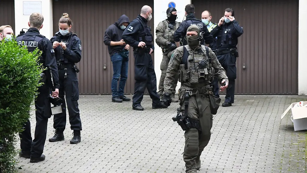 Einsatzkraefte-stehen-bei-einem-grossangelegten-Einsatz-gegen-die-Rauschgiftkriminalitaet-vor-einem-Buerogebaeude-in-Essen