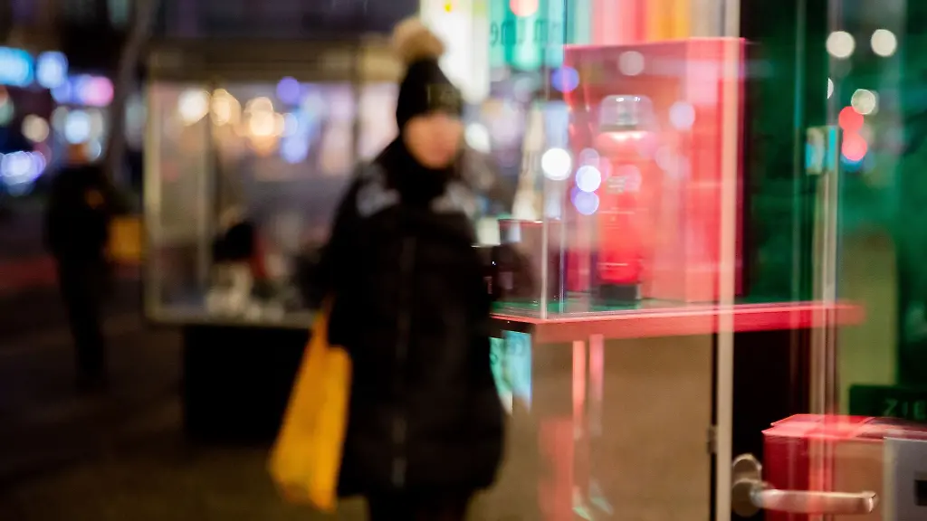 Die-Umrisse-einer-Passantin-spiegeln-sich-in-einem-Schaufenster