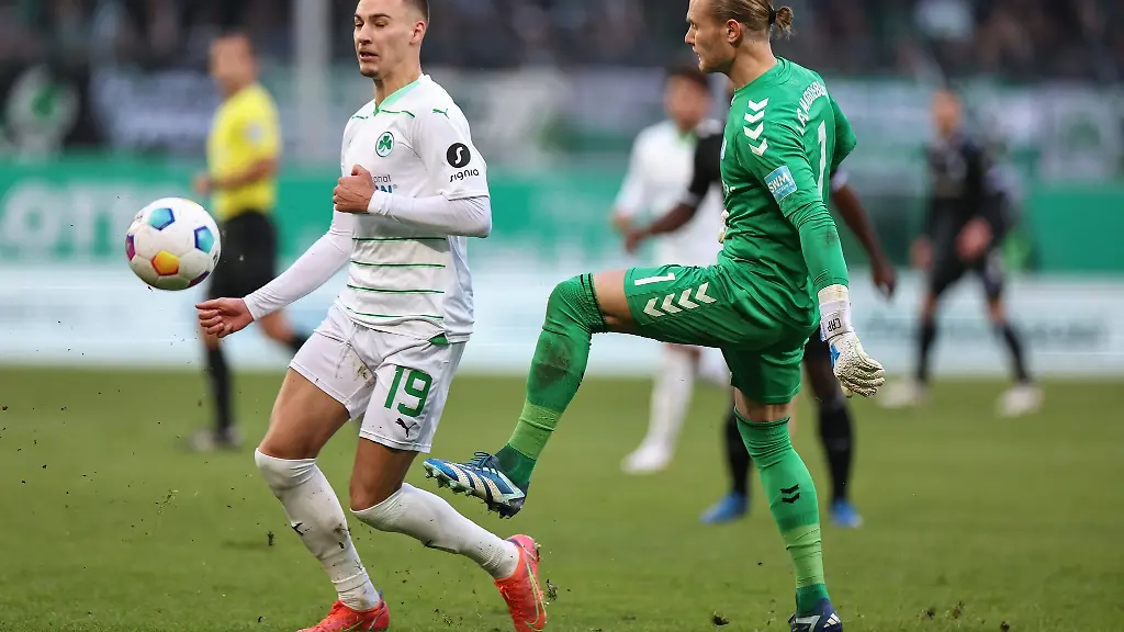 Der-Fuerther-Tim-Lemperle-l-kaempft-mit-Torwart-Dominik-Reimann-aus-Magdeburg-um-den-Ball