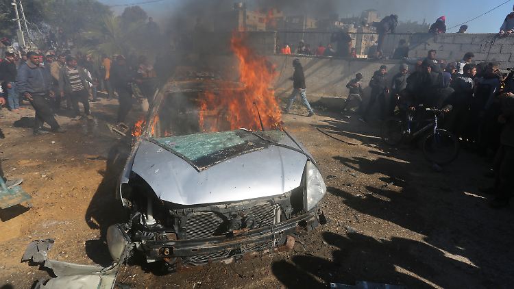 Palästinenser sehen zu wie ein Auto brennt, das bei einem israelischen Luftangriff auf Rafah getroffen wurde.