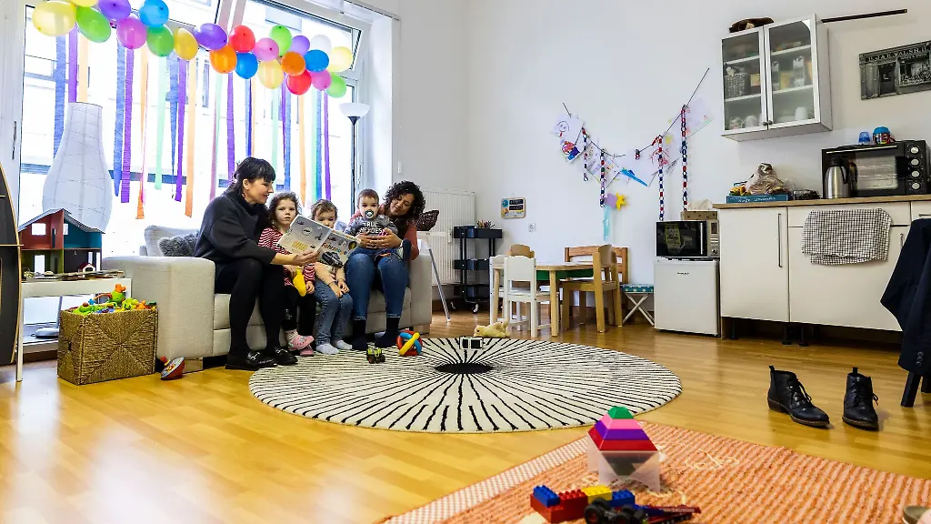 Projektleiterin-Nathalie-Laufenburg-links-und-Serah-Dubidad-lesen-Buecher-mit-Kindern-gefluechteter-ukrainischer-Frauen