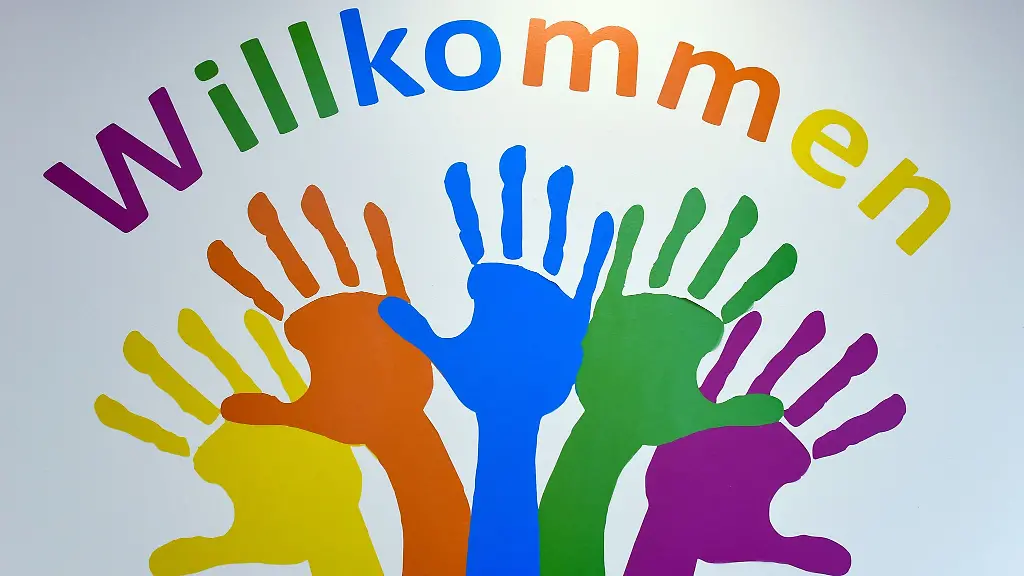 Bunte-Haende-und-das-Wort-Willkommen-ziert-eine-Wand