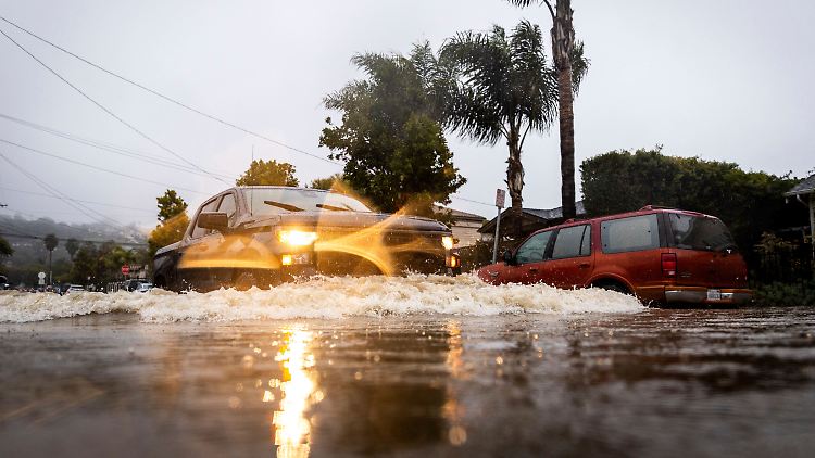 Autos fahren durch eine überflutete Straße im kalifornischen Santa Barbara. 