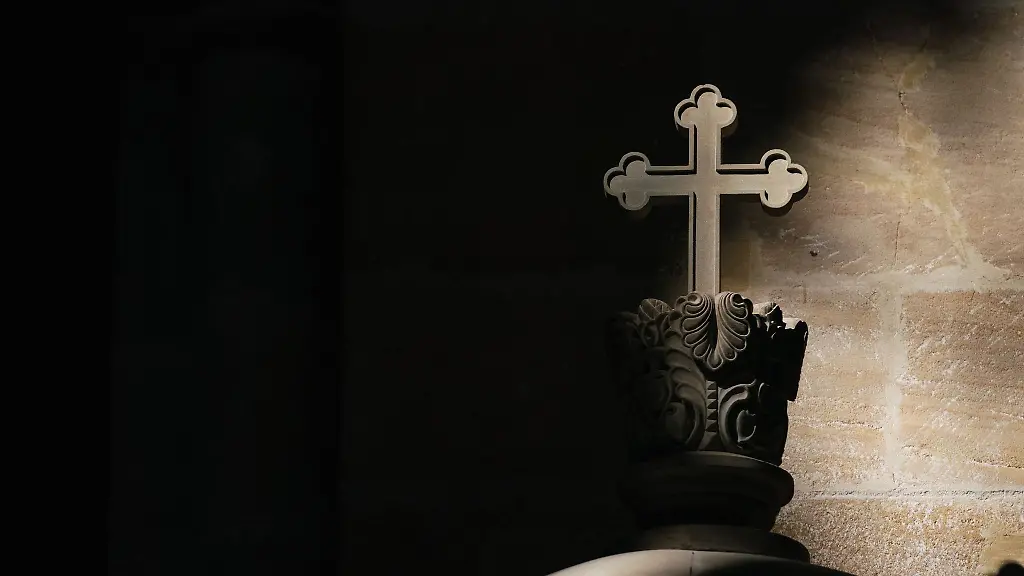 Ein-Lichtstrahl-faellt-in-einer-Kirche-auf-ein-Kreuz
