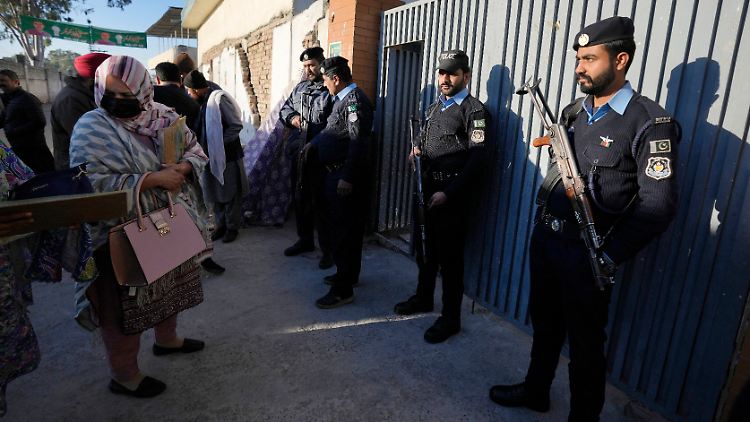 Polizeibeamte sichern die Stimmabgabe in einem Wahllokal. In Pakistan sind rund 130 Millionen Menschen wahlberechtigt.