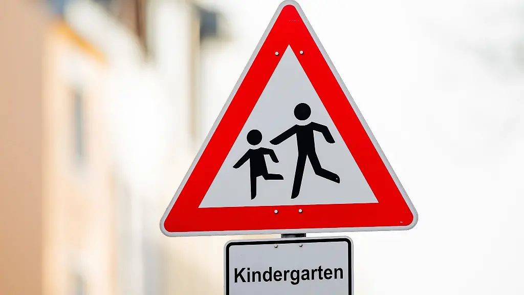 Ein-Verkehrsschild-mit-dem-Hinweis-Kindergarten-steht-vor-einer-Kindertagesstaette