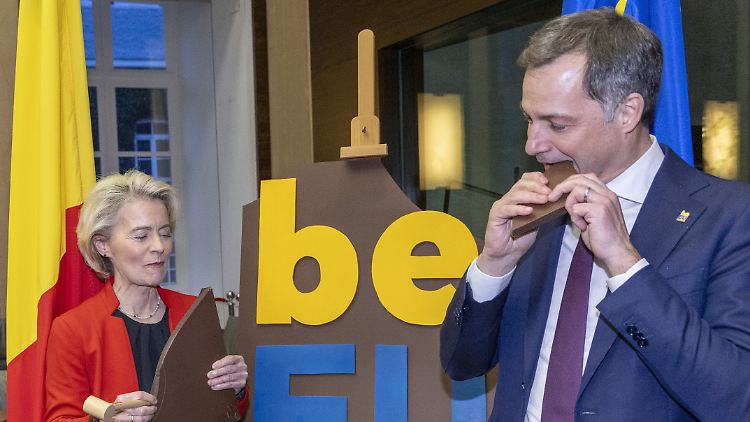 Zum Start des belgischen Ratsvorsitzes verzehren Ursula von der Leyen (l), Präsidentin der Europäischen Kommission, und Alexander De Croo, Premierminister von Belgien, ein Logo aus Schokolade.