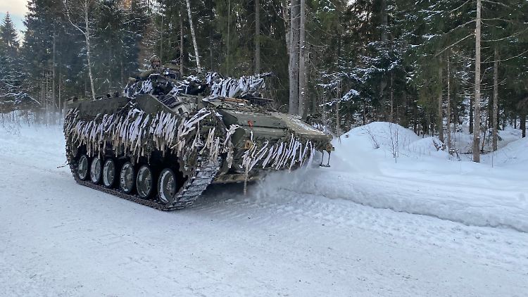 Ein britischer Schützenpanzer vom Typ Warrior fährt durch das verschneite Militärübungsgelände.