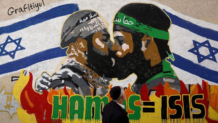 Ein orthodoxer Jude betrachtet ein Graffiti in Tel Aviv: Kuss unter Terror-Brüdern.