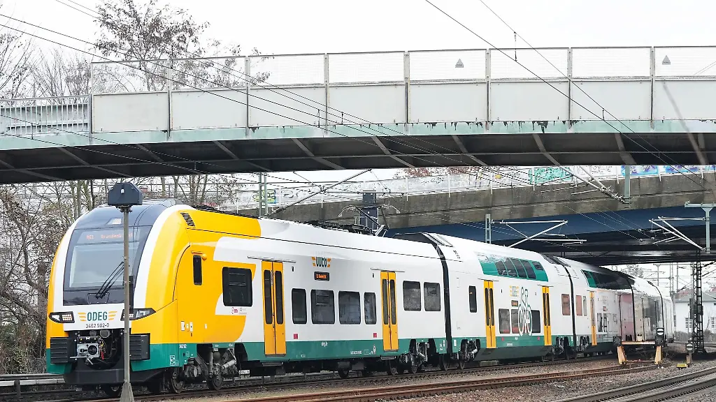 Ein-Zug-der-Ostdeutschen-Eisenbahn-GmbH-faehrt-unter-zwei-Bruecken-hindurch