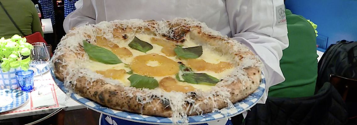 Gino hält Ananas Pizza in der Hand.png