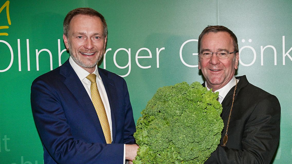 Lindner übergab dem neuen Grünkohlkönig Pistorius beim "Defftig Ollnborger Gröönkohl-Äten" mit einer Grünkohlpflanze sein Ehrenamt.