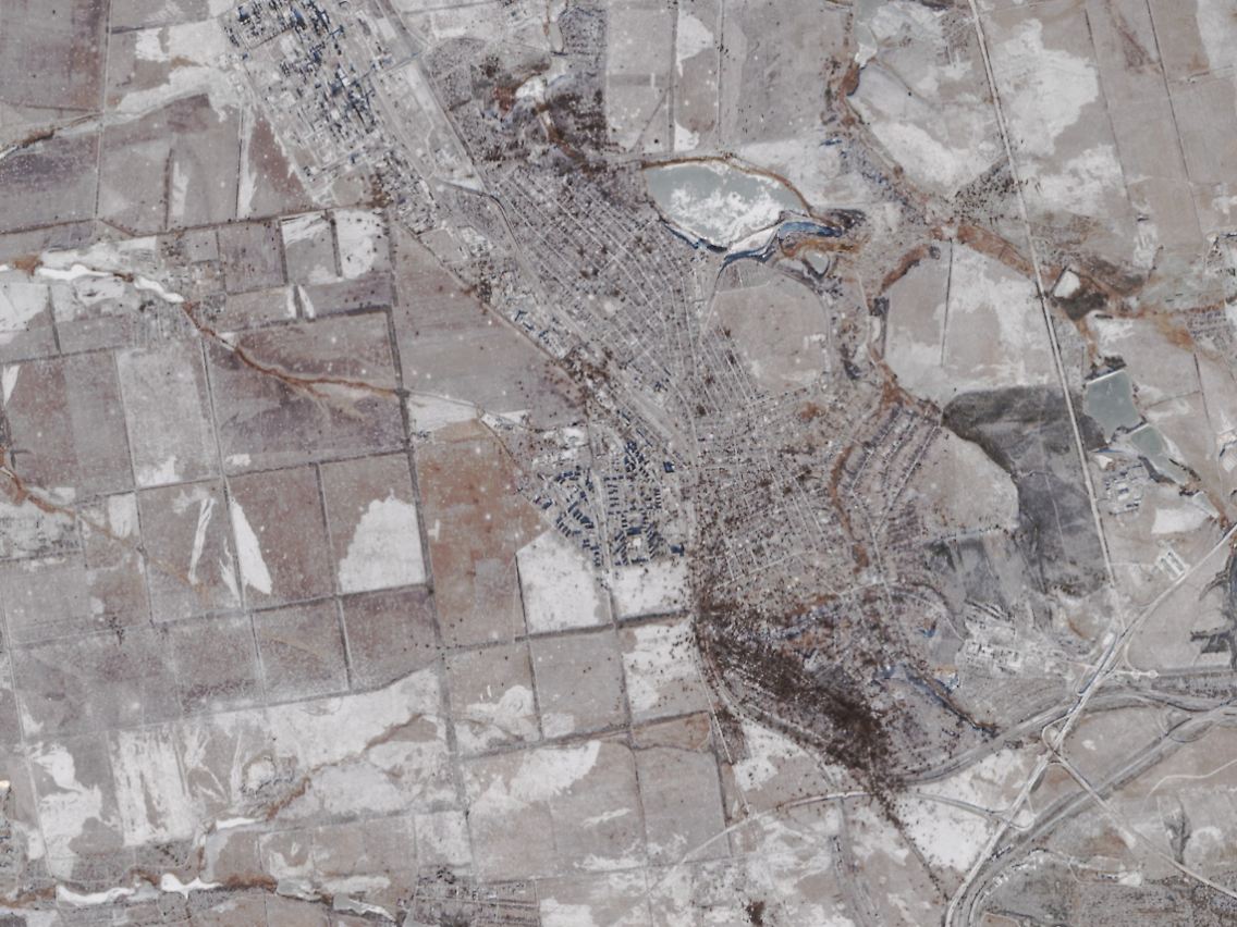 Satellitenaufnahme von Ende Januar 2024: Im verschneiten Gelände sind die Spuren des russischen Dauerbombardements rund um Awdijiwka als dunkle Flecken zu erkennen.