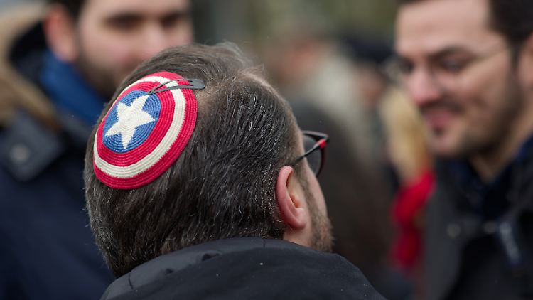 Auf einer Kundgebung von "Fridays for Israel" trägt ein junger Mann eine Kippa im Superheldendesign.