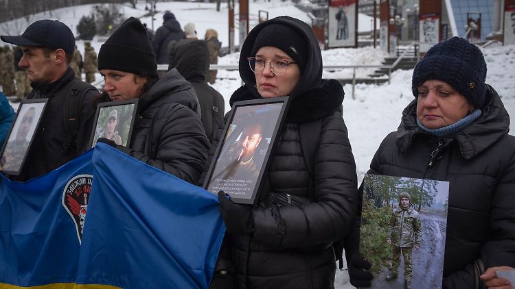 Angehörige von ukrainischen Soldaten, die von Russland gefangen genommen wurden, halten Fotos mit der Forderung ihrer Freilassung.