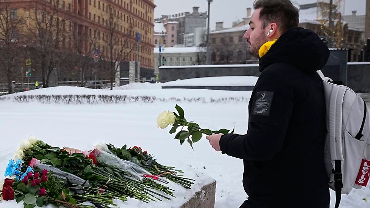 In Moskau legt ein junger Mann Blumen im Gedenken an Alexej Nawalny nieder. 
