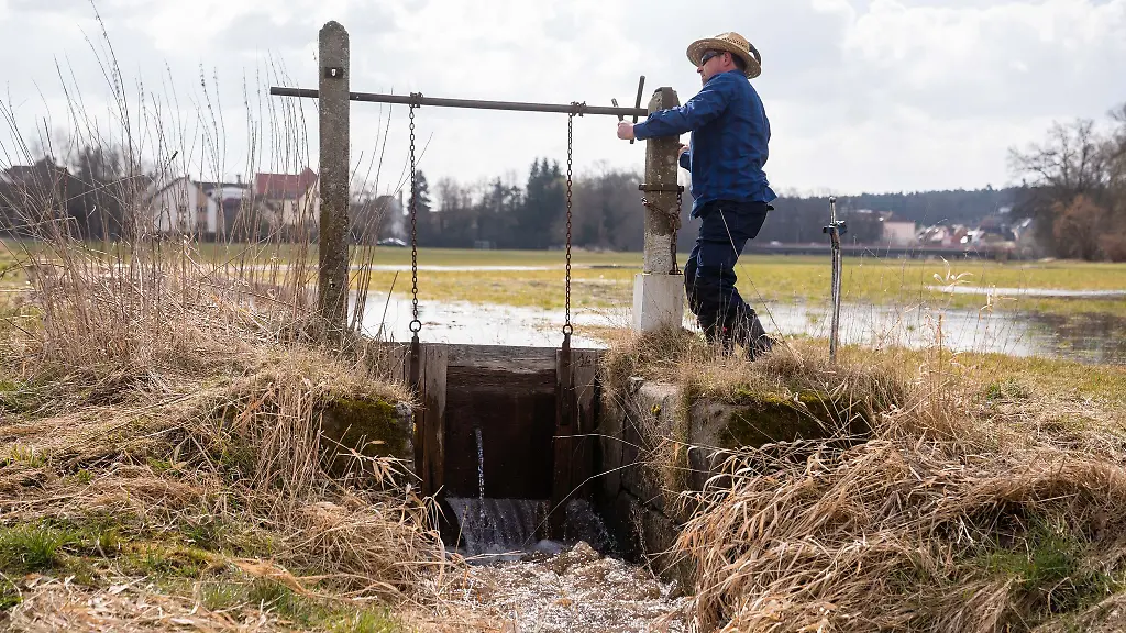 Der-Waesserer-Juergen-Zwingel-oeffnet-eine-Schleuse-eines-Waessergrabens-im-Ortsteil-Reichelsdorf