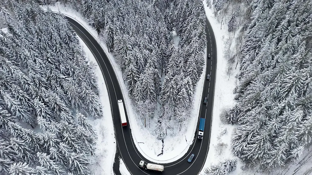 Autos-fahren-im-winterlichen-Harz-ueber-eine-Strasse-die-durch-den-Wald-fuehrt