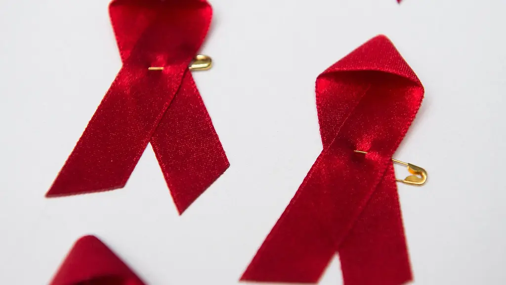 Viele-rote-Schleifen-das-weltweit-anerkannte-Symbol-fuer-die-Solidaritaet-mit-HIV-Infizierten-liegen-am-Welt-Aids-Tag-auf-einem-Tisch