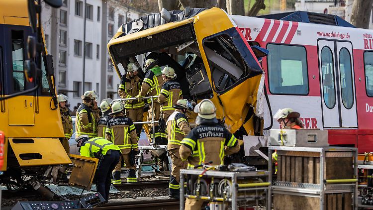 Einsatzkräfte der Feuerwehr arbeiten an zwei zerstörten Stadtbahnen. Bei dem Zusammenstoß wurden die Führerhäuser stark deformiert.  