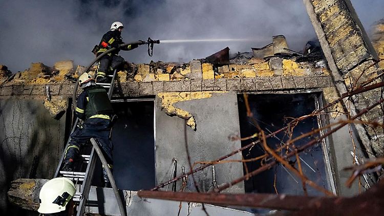 Feuerwehrleute löschen ein brennendes Gebäude nach einem russischen Angriff auf Odessa. 