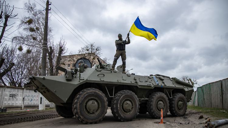 Freiheitswille gegen Putins Militärmaschinerie: Auf einem Transportpanzer stehend schwenkt ein ukrainischer Soldat die ukrainischen Farben.