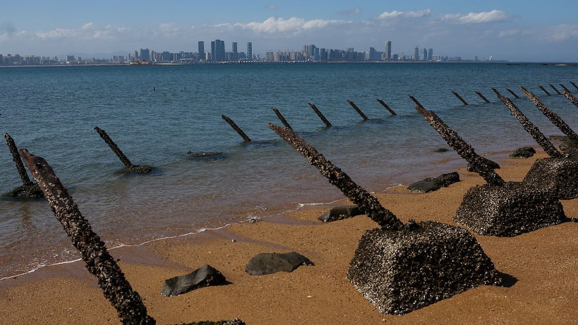 Antilandungsbarrikaden am Strand von Kinmen mit der chinesischen Stadt Xiamen im Hintergrund.