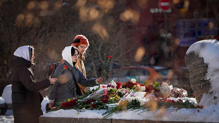 Jugendliche in Russland legen Blumen nieder, um Nawalny die letzte Ehre zu erweisen.