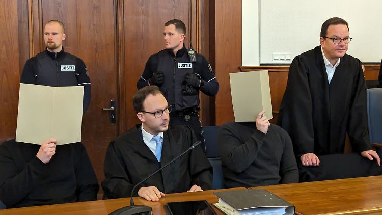 Der angeklagte Polizeibeamte (2.v.r.), der geschossen hat, sitzt neben seinem Anwalt im Gerichtssaal des Landgerichts Dortmund.