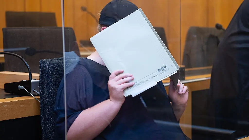 Zu-Beginn-des-Prozesses-sitzt-die-Mutter-eines-Opfers-im-Landgericht-Muenster-und-verdeckt-ihr-Gesicht-mit-einer-Mappe