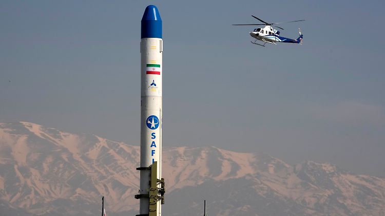 Ein Hubschrauber fliegt über einen Satellitenträger, der während der jährlichen Kundgebung zum Gedenken an die Islamische Revolution von 1979 in Teheran ausgestellt wird.