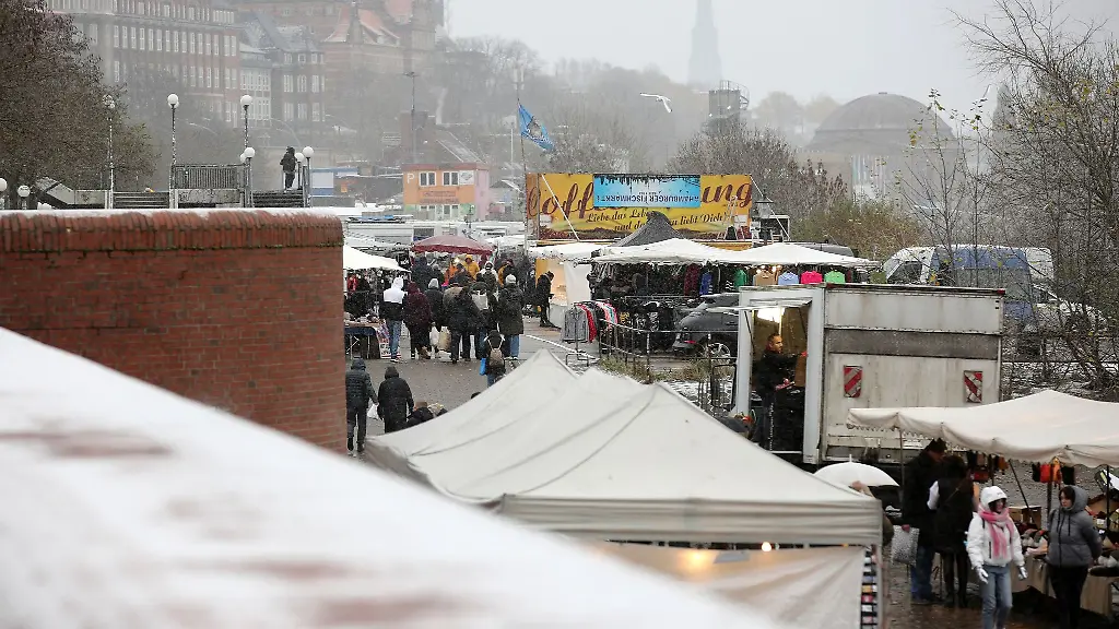 Bei-leichtem-Schneefall-sind-Besucher-auf-dem-Hamburger-Fischmarkt-unterwegs