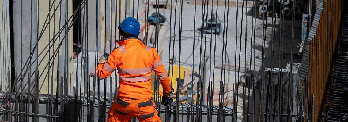 Harter Arbeitsalltag: Ein Bauarbeiter verlegt auf einer Baustelle Stahlmatten.