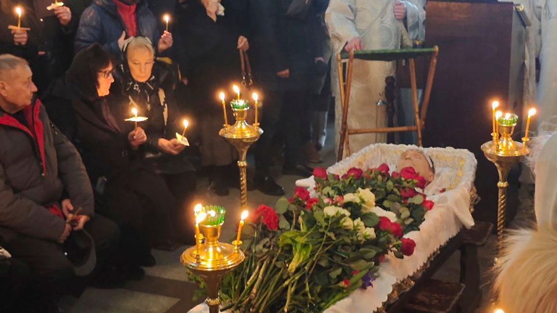 Nawalny liegt im offenen Sarg in der Kirche, umringt von Verwandten.
