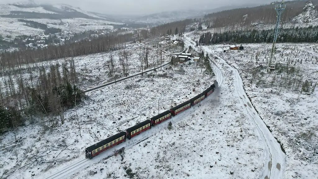 Ein-Zug-faehrt-durch-den-verschneiten-Wald-in-Richtung-Schierke