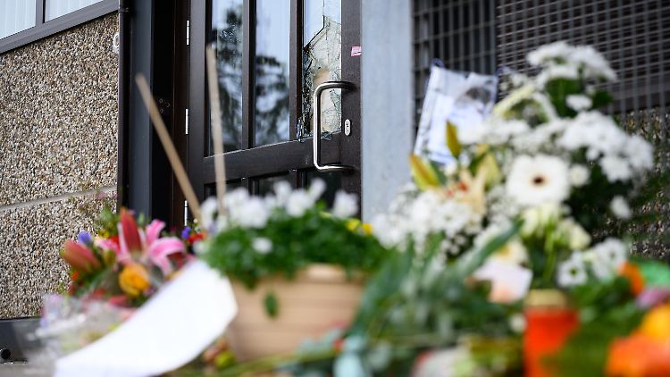 Blumen und Kerzen sind vor dem Eingangsbereich eines Gemeindehauses der Zeugen Jehovas in Hamburg zu sehen. Bei einem Amoklauf sind am 9. März 2023 dort acht Menschen getötet und elf weitere Personen verletzt worden.