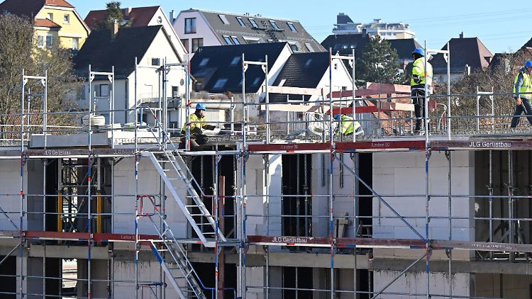 Auf einer Baustelle für Wohnungen und Sozialwohnungen arbeiten Bauarbeiter am Rohbau.