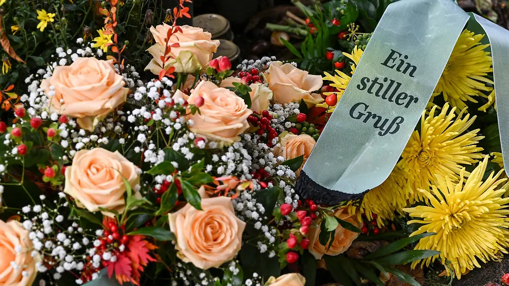 Eine-Trauerschleife-mit-der-Aufschrift-Ein-stiller-Gruss-liegt-auf-einer-Grabanlage