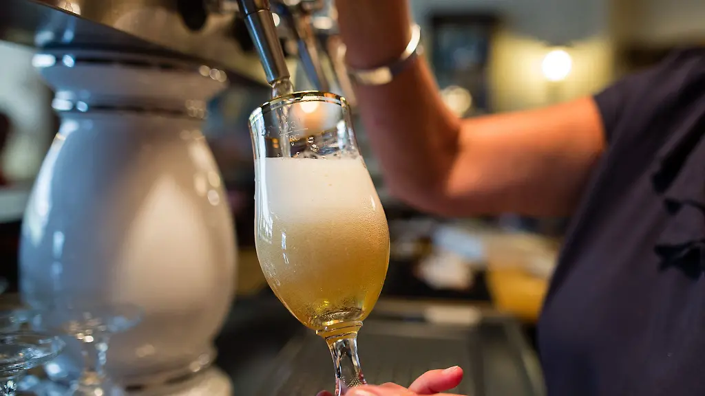 Eine-Frau-zapft-in-einer-Gaststaette-ein-Pils