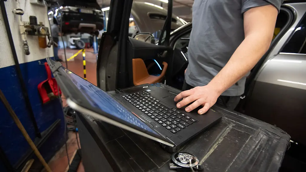 Ein-KFZ-Mechaniker-wartet-in-einer-KFZ-Werkstatt-einen-Wagen