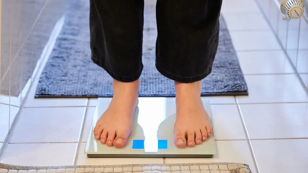 Eine-Jugendliche-steht-auf-einer-Waage-im-Badezimmer