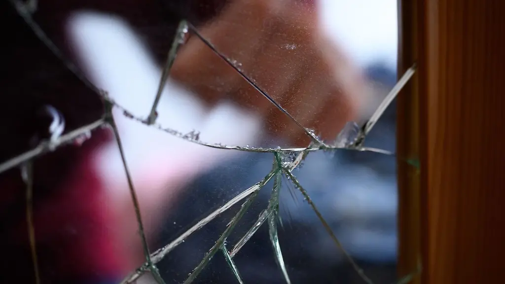 Eine-zeigt-auf-einen-gesprungenen-Spiegel