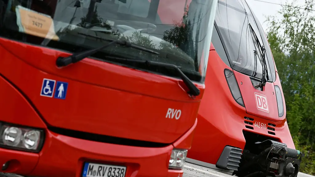 Ein-Regionalbus-und-ein-Regionalzug-stehen-am-Bahnhof-in-Murnau-nebeneinander