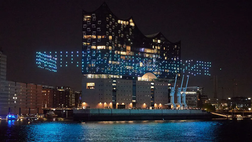 Beleuchtete-Drohnen-fliegen-ueber-der-Elbe-vor-der-Elbphilharmonie-zur-Eroeffnung-des-Musikfests